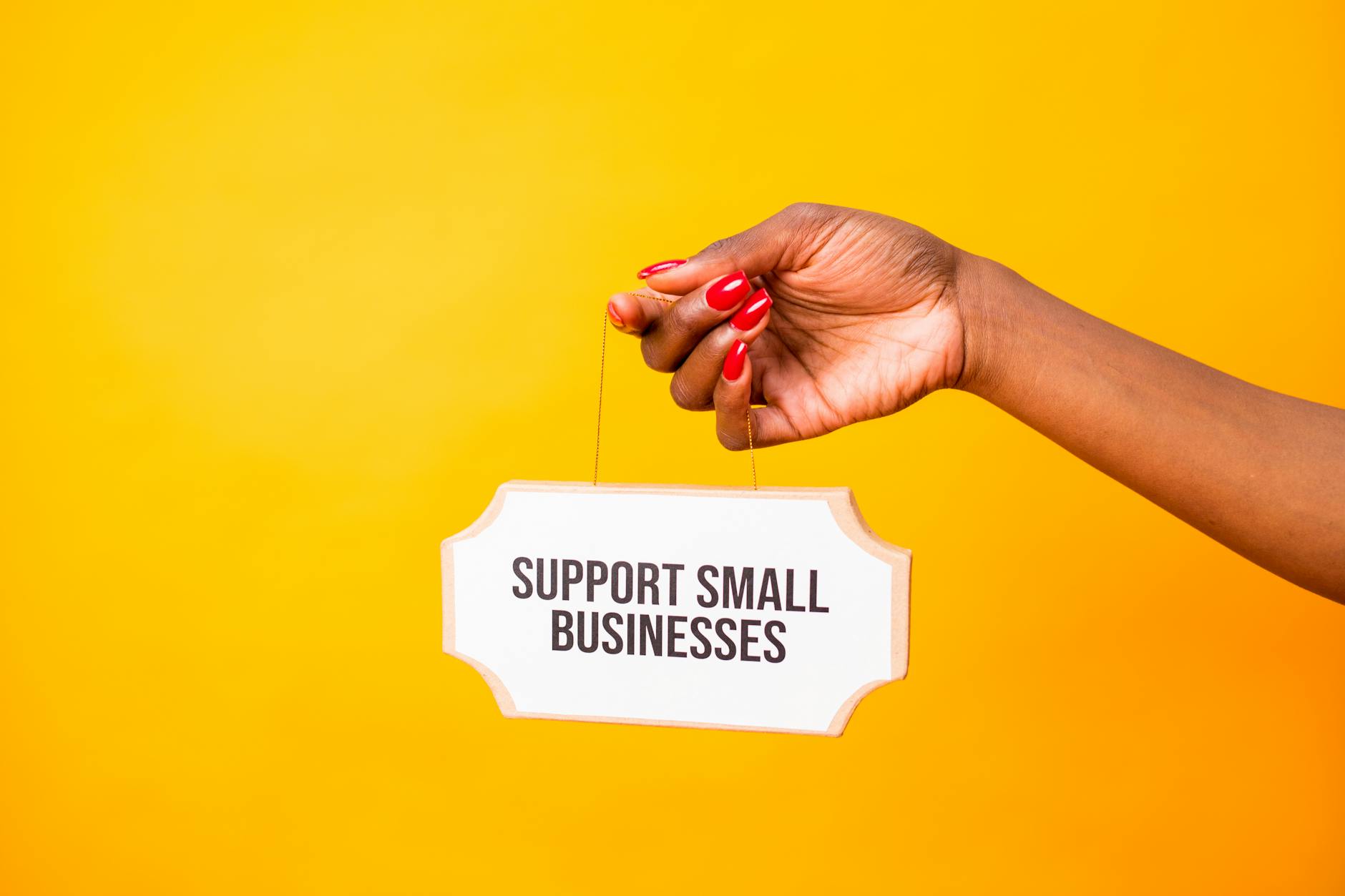 Small business owner holding support sign to encourage Google reviews from local customers
