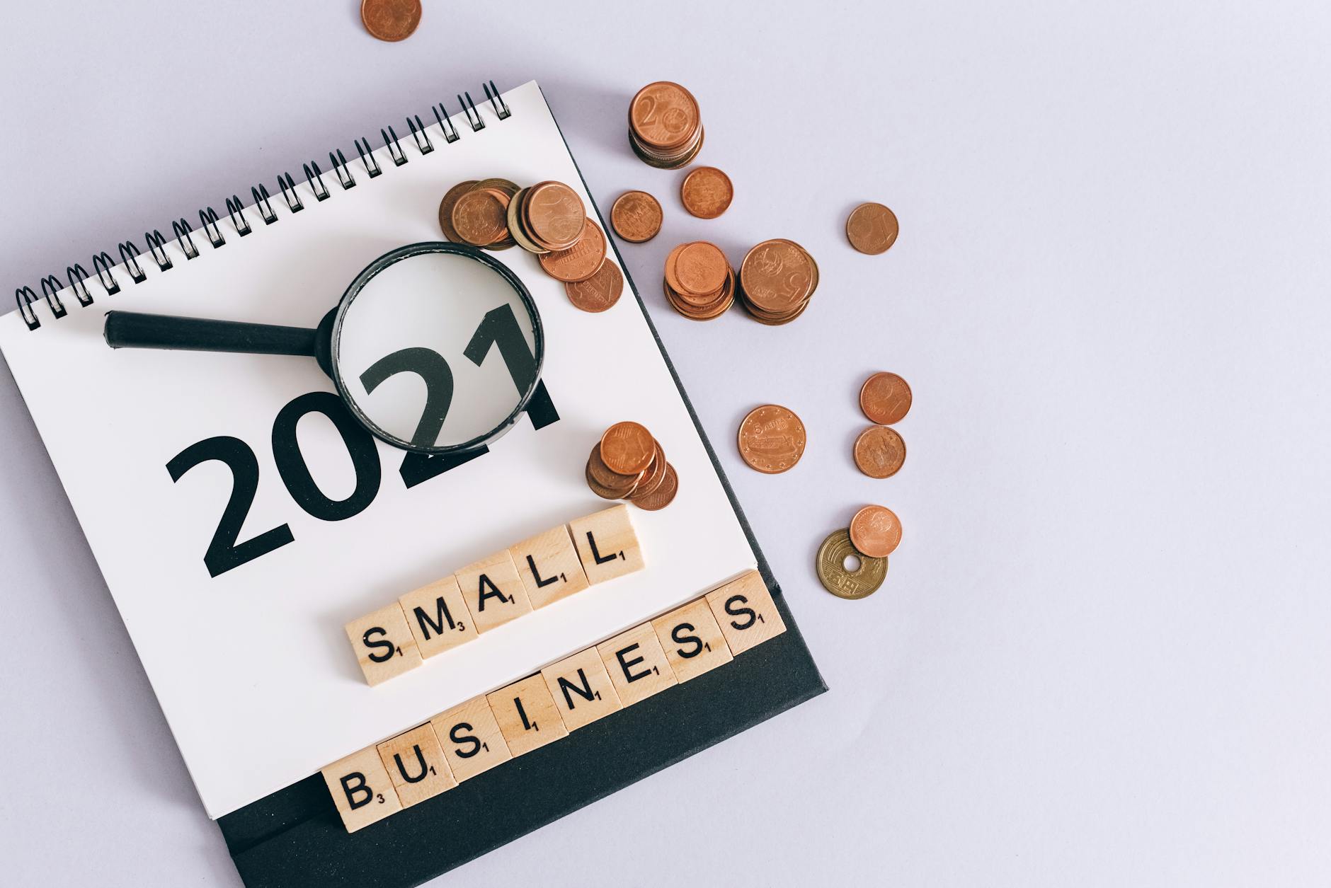 Small business budget planning with calendar, coins, and magnifying glass for paid media strategy