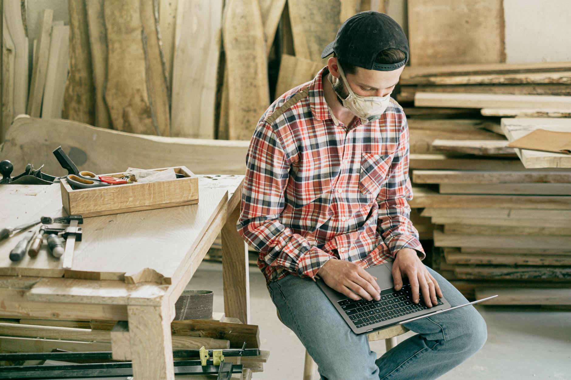 Small business owner building their website using laptop in workshop setting