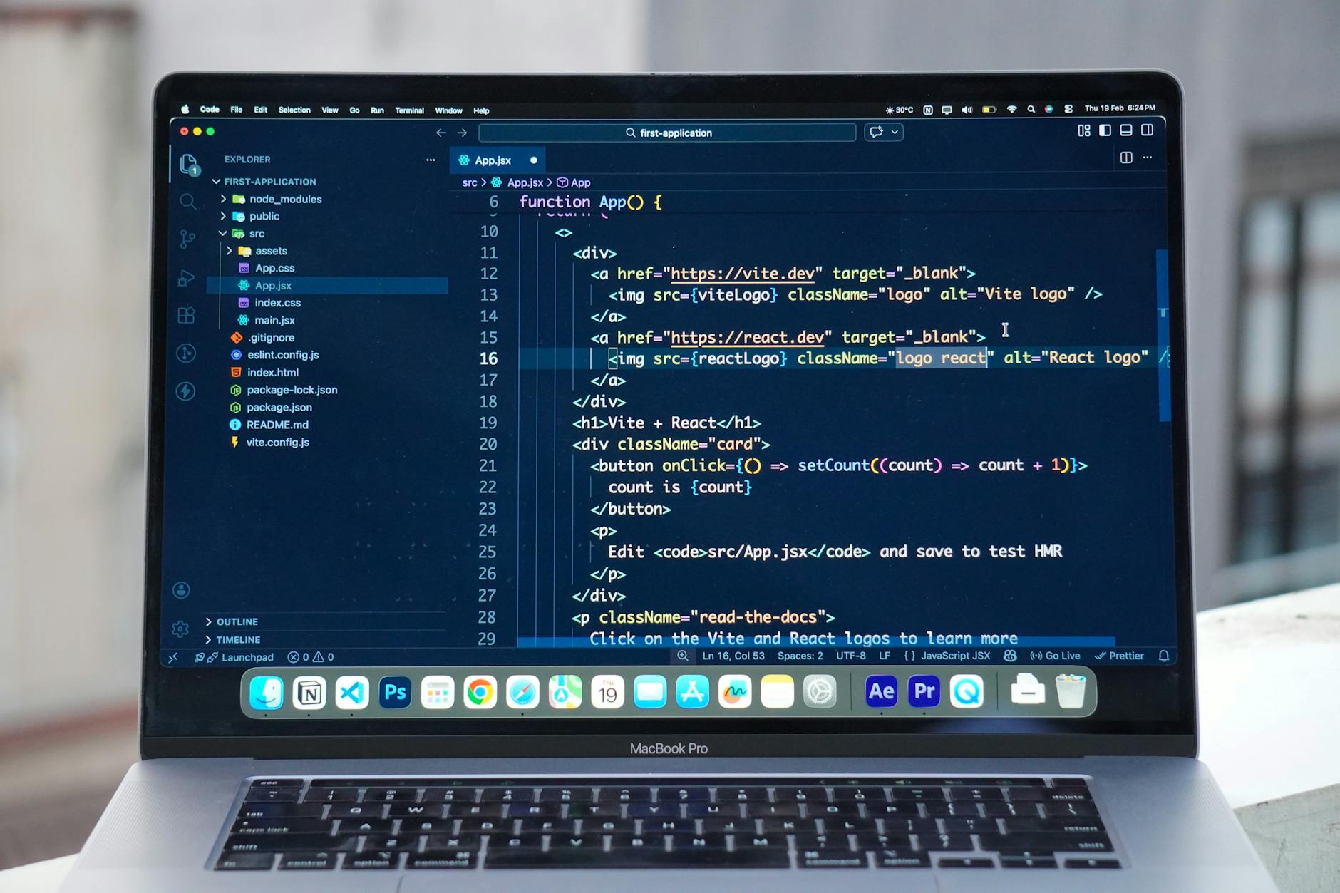 A MacBook Pro displaying code editor on a rooftop setting in daylight, ideal for a remote work lifestyle.